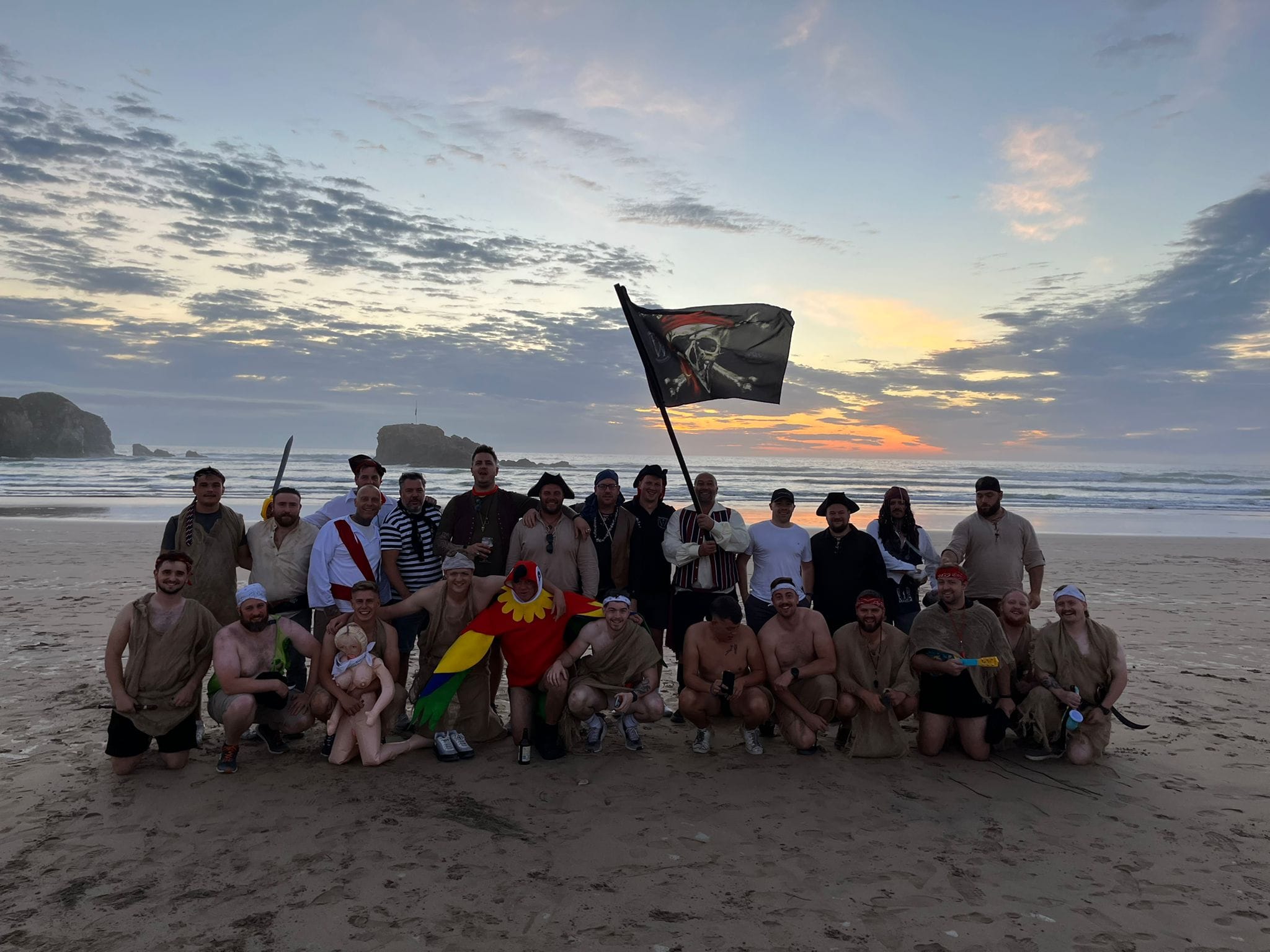 Club members gathered on a beach with the club flag on tour