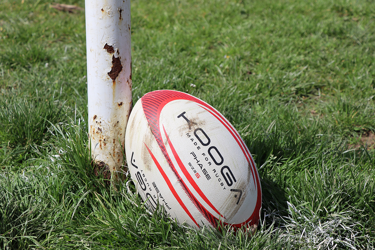 Match ball resting against the foot of a rugby post