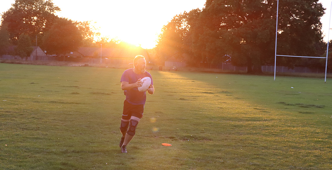Player running with the ball at sunset