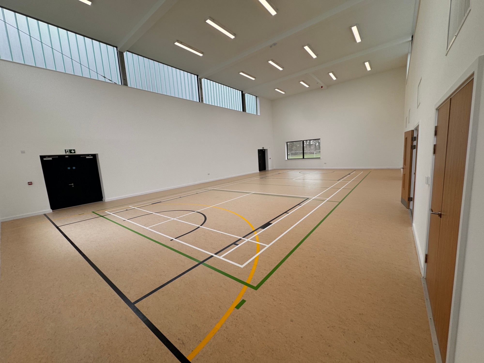 Bright indoor sports hall with marked courts and high windows