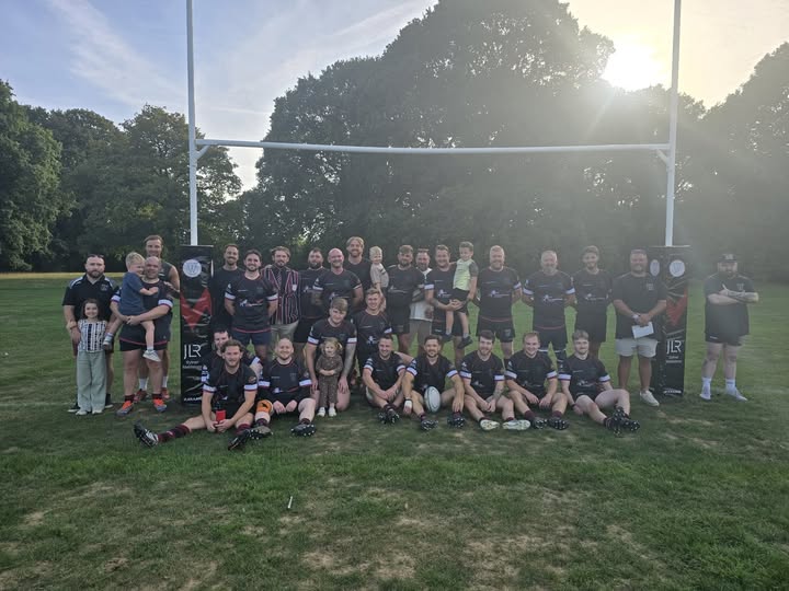 The squad and their families lined up under the posts on the pitch